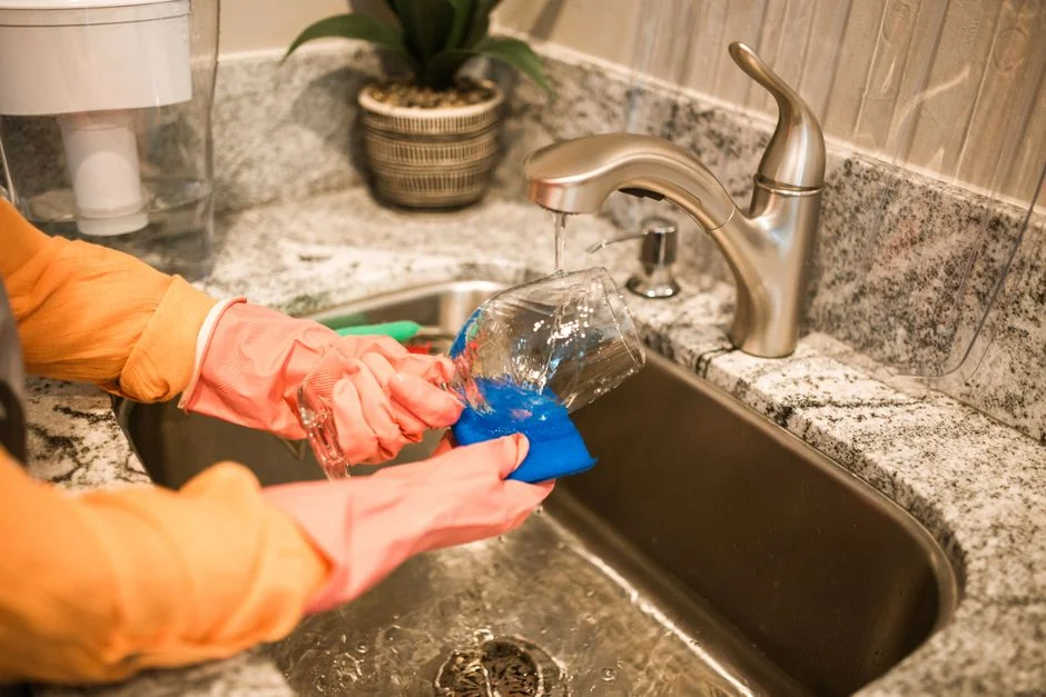 a-woman-is-cleaning-a-kitchen-sink-with-a-rag-sqomdoqb3ws